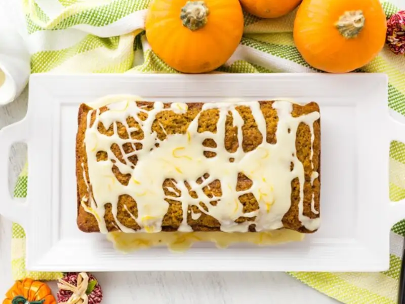 Bizcocho de calabaza esponjoso recién horneado, decorado con un glaseado de queso crema .